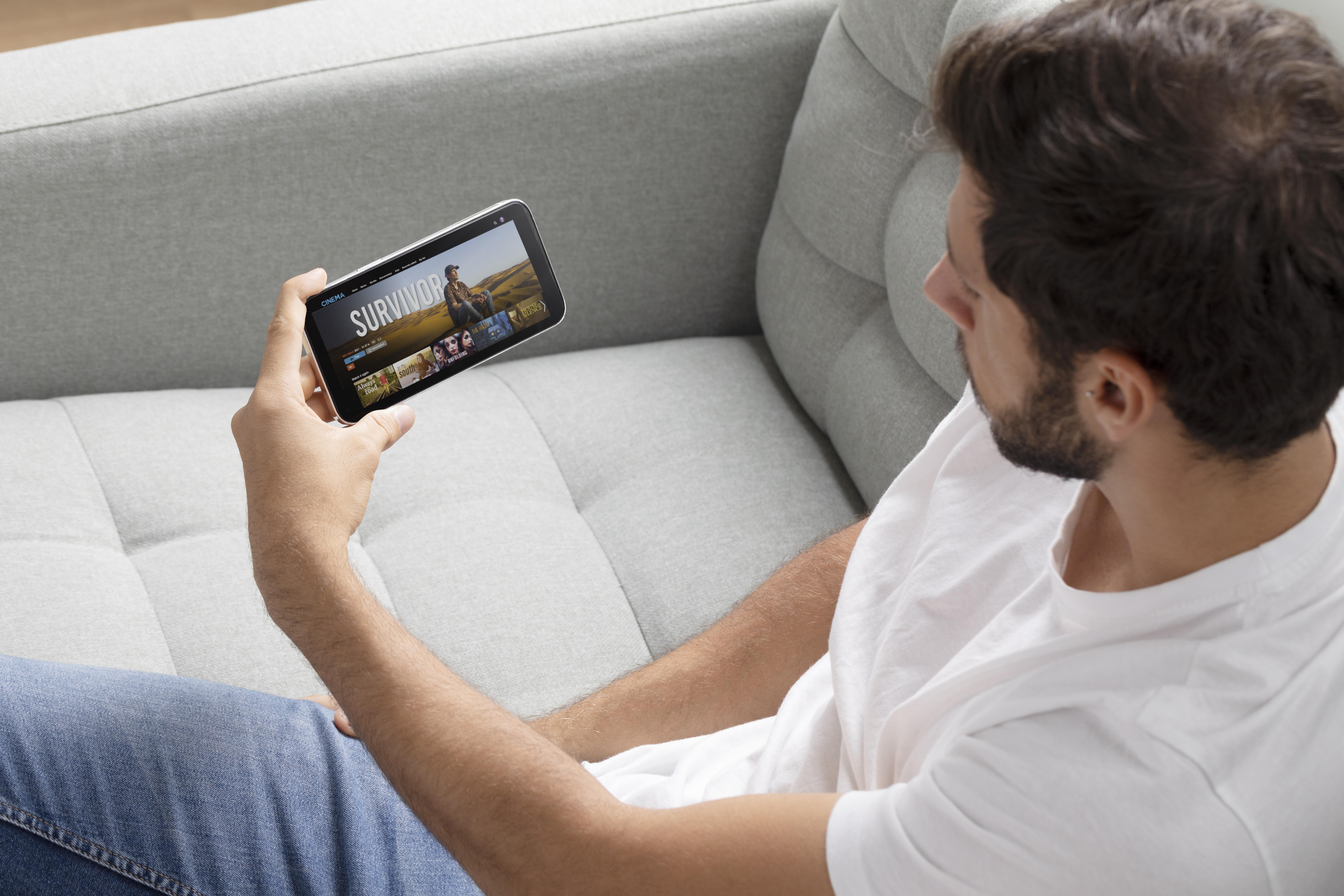 Telefonda yatay ekranda yayın izleyen kişi